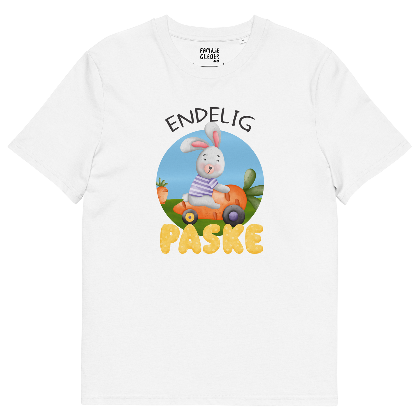 Hvit t-skjorte som ligger flatt, med teksten "Endelig påske" og figur av en glad kanin som kjører en gulrotbil. Foto.