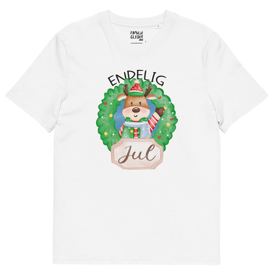 Hvit t-skjorte som ligger flatt, med teksten "Endelig jul" og figur av en søt elg i julete klær med en julekrans rundt seg. Foto.