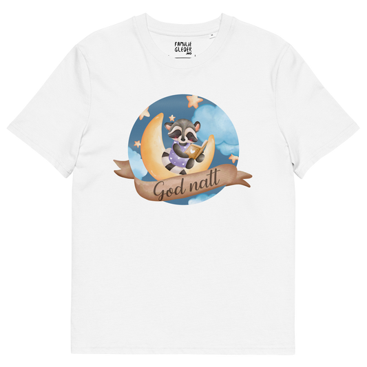 Hvit t-skjorte som ligger flatt, med teksten "God natt" og figur av en lykkelig vaskebjørn som sitter på månen og leser en bok. Foto.